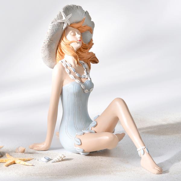 Statuette femme assise au chapeau de paille